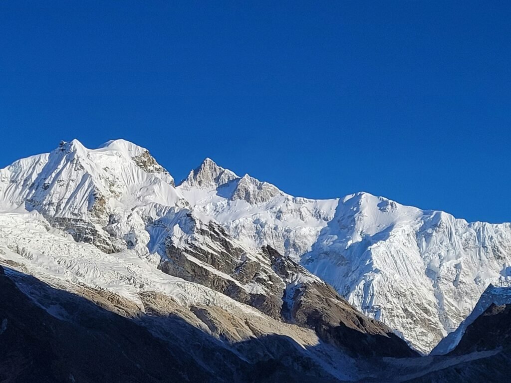 Snow-covered peaks of the Himalayan mountains under a clear blue sky.